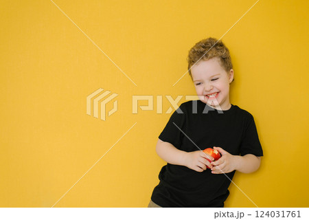 Boy Holding A Red Apple By Yellow Wall Boy Holding A Red Apple By Yellow Wall 124031761