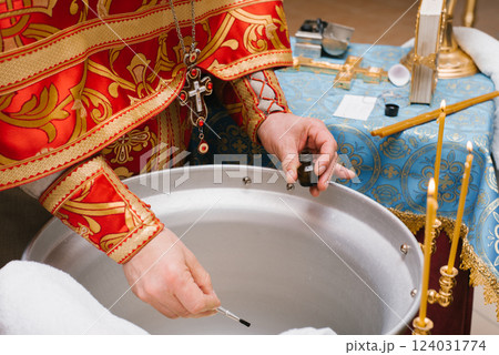 Priest Preparing Baptism Water with Holy Oil 124031774