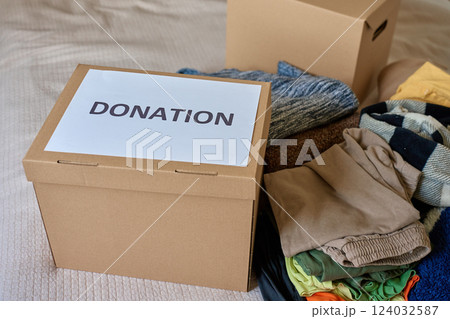 Clothes prepared for donation in cardboard box 124032587