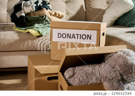 Clothes and toys prepared for donation in cardboard box 124032594