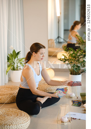A sporty girl lays out Tarot cards indoors. Tarot cards in the hands of a fortune teller A sporty girl lays out Tarot cards indoors. Tarot cards in the hands of a fortune teller 124032618
