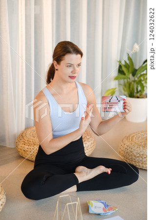 A sporty girl lays out Tarot cards indoors. Tarot cards in the hands of a fortune teller A sporty girl lays out Tarot cards indoors. Tarot cards in the hands of a fortune teller 124032622