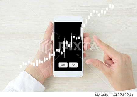 スマホで投資をする人物のイメージ画像 124034018