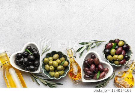 Black, green and kalamata olives with olive oil and olive branches  124034165