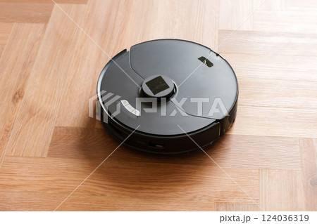 Robot vacuum cleaner performs automatic cleaning of the apartment at a certain time. Smart home. Robot vacuum cleaner performs automatic cleaning of the apartment at a certain time. Smart home. 124036319