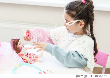 Child playing doctor with doll Child playing doctor with doll 124036336