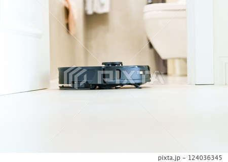 Robot vacuum cleaner performs automatic cleaning of the apartment at a certain time. Smart home. Robot vacuum cleaner performs automatic cleaning of the apartment at a certain time. Smart home. 124036345