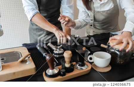 Coffee Preparation and Artisan Skills. Baristas collaboratively showcasing their skills in brewing and serving coffee. 124036675