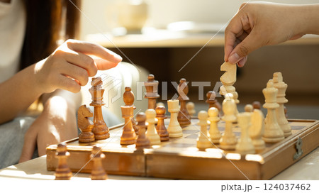 Close up of friends playing chess under warm natural light Close up of friends playing chess under warm natural light 124037462