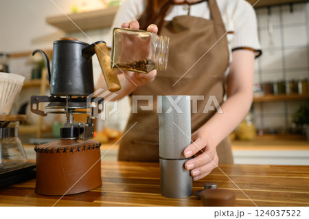 Young woman grinds coffee beans and sets up a brewing station in a modern kitchen 124037522