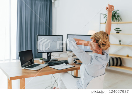 Feeling successful and relaxed. Female stock broker in formal wear is working in the office 124037987