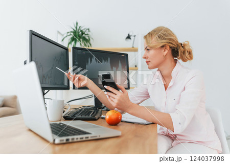 Monitoring the market. Female stock broker in formal wear is working in the office 124037998