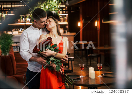 Man giving beautiful flowers. Romantic couple have dinner in the restaurant 124038557