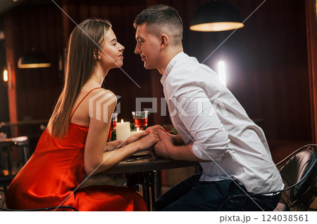 Side view. Romantic couple have dinner in the restaurant Side view. Romantic couple have dinner in the restaurant 124038561
