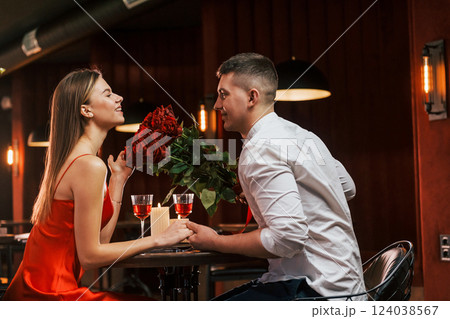 In red dress and white shirt. Romantic couple have dinner in the restaurant In red dress and white shirt. Romantic couple have dinner in the restaurant 124038567
