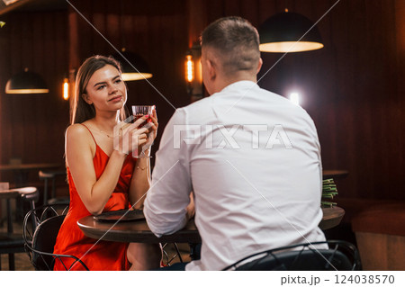 In red dress and white shirt. Romantic couple have dinner in the restaurant In red dress and white shirt. Romantic couple have dinner in the restaurant 124038570