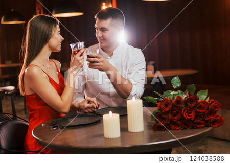 Sitting with drinks by the table together. Romantic couple have dinner in the restaurant 124038588