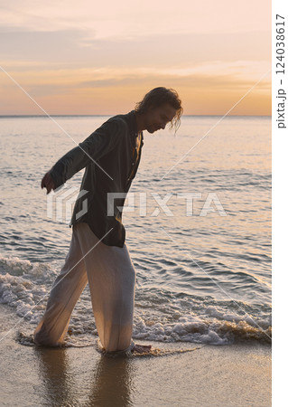 happy boy on the beach at sunset. young handsome wet man happy boy on the beach at sunset. young handsome wet man 124038617