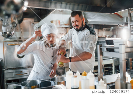 Man and woman cooking meal. Professional chef preparing food in the kitchen 124039174