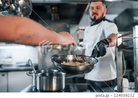 Pouring ingredients. Professional chef preparing food in the kitchen Pouring ingredients. Professional chef preparing food in the kitchen 124039212