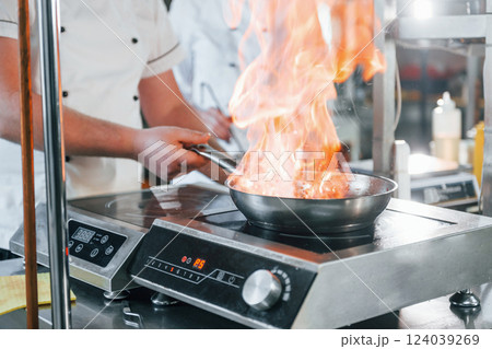 Food is igniting and weight getting measured. Professional chef preparing food in the kitchen Food is igniting and weight getting measured. Professional chef preparing food in the kitchen 124039269