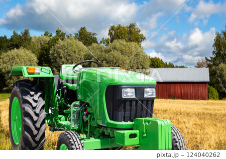 Green tractor on a agricultural field Green tractor on a agricultural field 124040262
