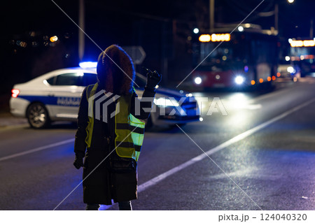Protester with police cars in the background at night Protester with police cars in the background at night 124040320