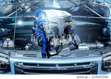 Fuel cell engine on the background of hydrogen powered car with open hood Fuel cell engine on the background of hydrogen powered car with open hood 124040368