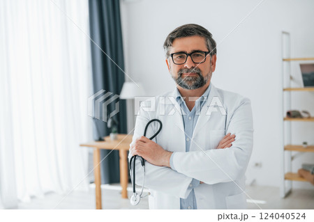 Male doctor is with stethoscope. Professional medical worker in white coat is in the office Male doctor is with stethoscope. Professional medical worker in white coat is in the office 124040524
