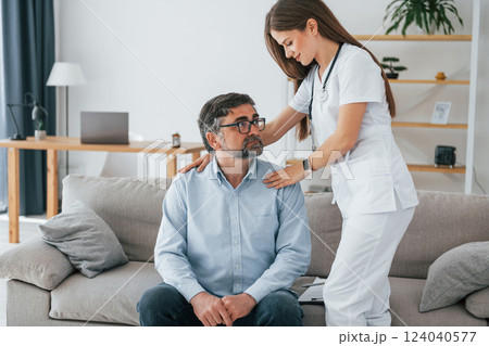 Working with mature man. Professional nurse is in white coat is in the office 124040577