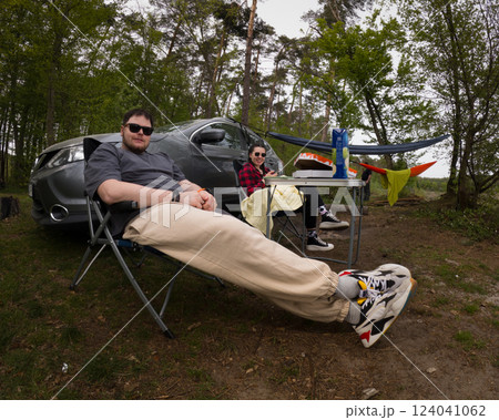 Couple Relaxing at Campsite with Hammock and Car 124041062