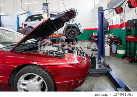 Car service workshop with cars on a column lifts Car service workshop with cars on a column lifts 124041383