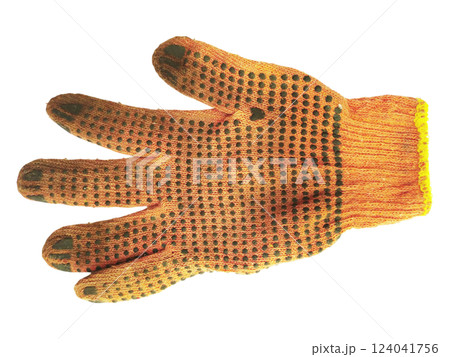 A wellworn orange work glove, showcasing its textured surface and darkcolored grip dots, lies against a clean white background. The image evokes themes of hard work, manual labor, and resilience. 124041756