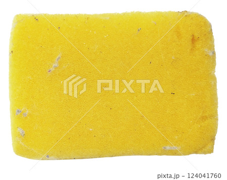 A wellused yellow cleaning sponge, slightly soiled, sits on a stark white background. 124041760