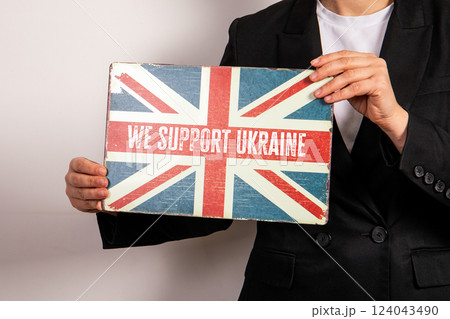 We support Ukraine. British flag in a woman's hands 124043490