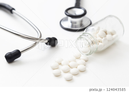 白背景に聴診器と薬 124043585