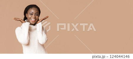 Portrait of sweet african woman touching her cheeks with hands over beige background, panorama with copy space Portrait of sweet african woman touching her cheeks with hands over beige background, panorama with copy space 124044146