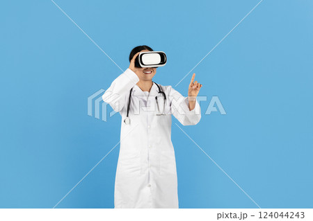 A healthcare professional, Asian lady dressed in a lab coat and stethoscope, joyfully engages with virtual reality equipment, showcasing innovative medical technology in a bright environment. A healthcare professional, Asian lady dressed in a lab coat and stethoscope, joyfully engages with virtual reality equipment, showcasing innovative medical technology in a bright environment. 124044243