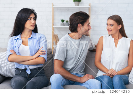 Jealousy And Cheating. Sad Girl Looking At Her Boyfriend Flirting With Another Woman Sitting On Sofa At Home. 124044250