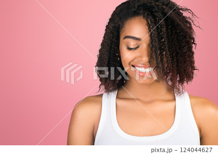 Shy Girl. Portrait of beautiful african american woman looking down and smiling over white background 124044627