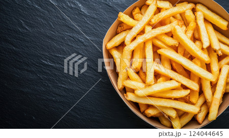 Crispy french fries in a brown paper bowl on a dark slate surface, AI Generative Crispy french fries in a brown paper bowl on a dark slate surface, AI Generative 124044645