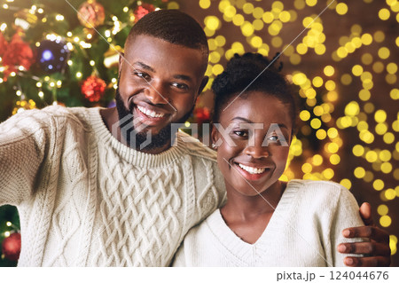 Xmas selfie. Happy black couple taking self-portrait with Christmas tree on background, celebrating holidays. Xmas selfie. Happy black couple taking self-portrait with Christmas tree on background, celebrating holidays. 124044676