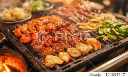 Grilling a variety of meats and vegetables at a lively outdoor barbecue 124045647
