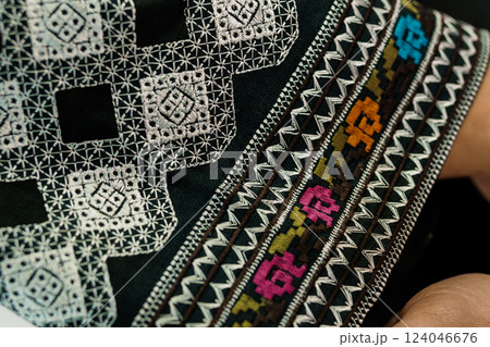 Close-up of Intricate Traditional Textile Embroidery Featuring Geometric Patterns and Colorful Floral Designs 124046676