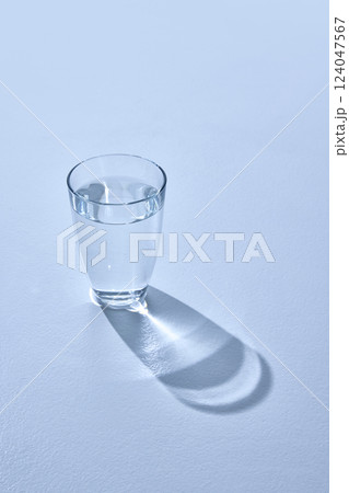 View from above of clear glass with transparent liquid against white studio background. One glass of water. Mock up. 124047567