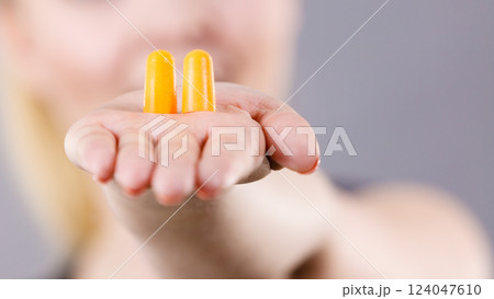Woman holding protective earplugs 124047610