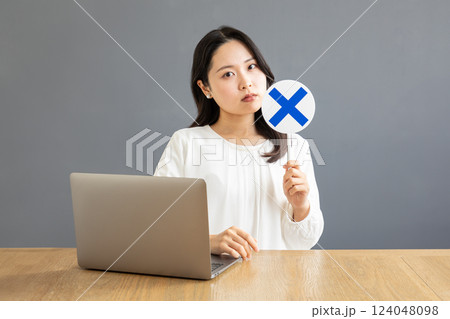 バツ印を出すPC前のアジア人女性02 124048098