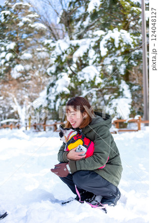 雪遊びする女性と愛犬 124048127