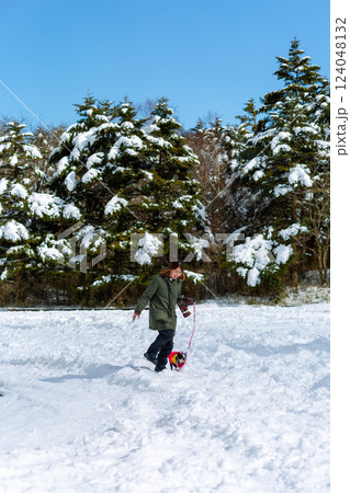 雪遊びする女性と愛犬 124048132