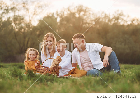 Sitting on the green grass. Family have weekend outdoors at summertime together 124048315